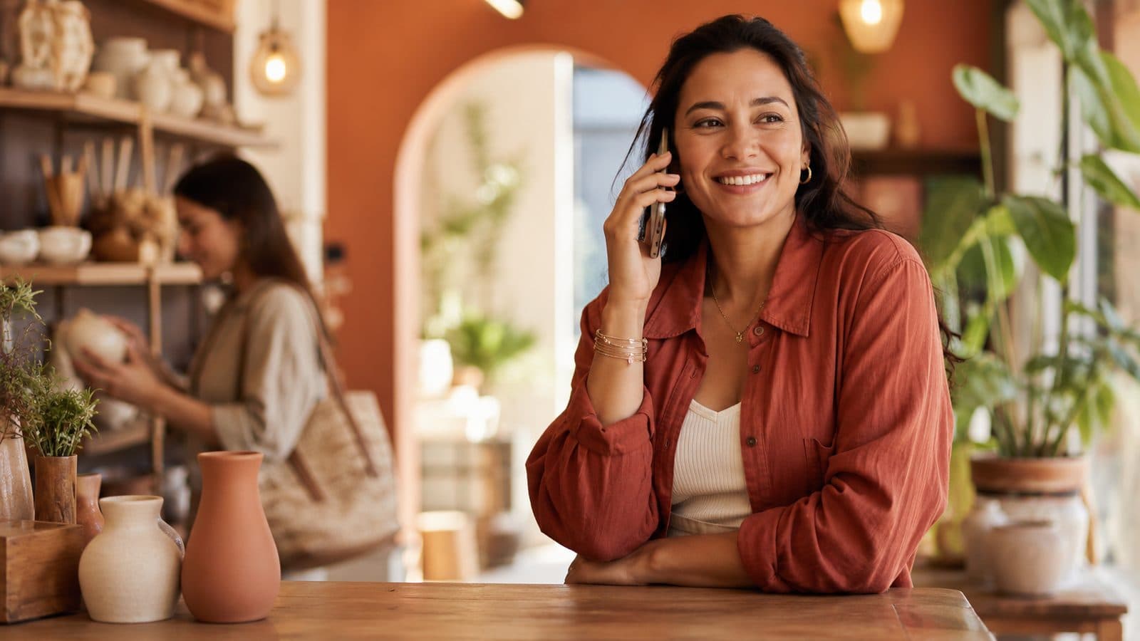 Small-business owner answering a customer call at the counter of her shop